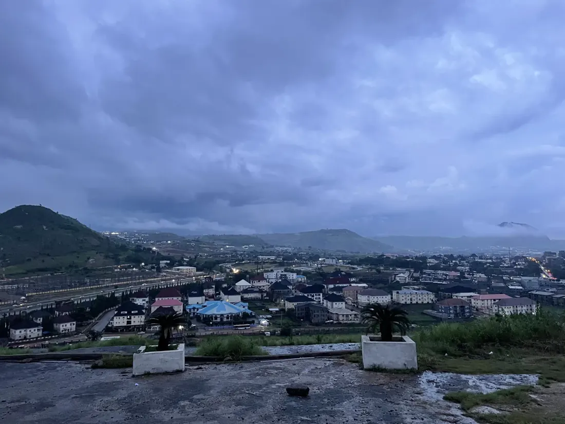Abuja's urban landscape and hills seen from Katampe Hill at dusk.